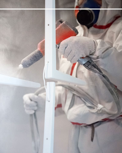 Man in protective gear completing powder coating
